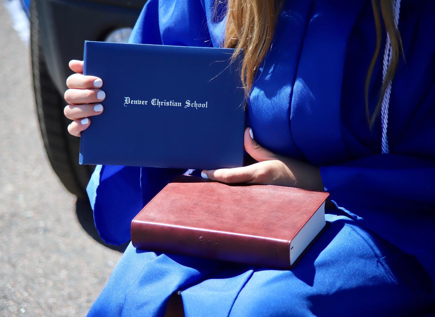 student holding up DCS diploma