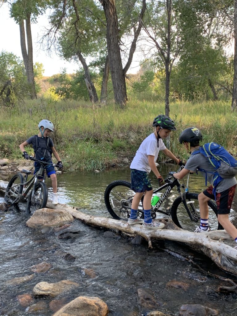 Kids crossing the creek with their bikes